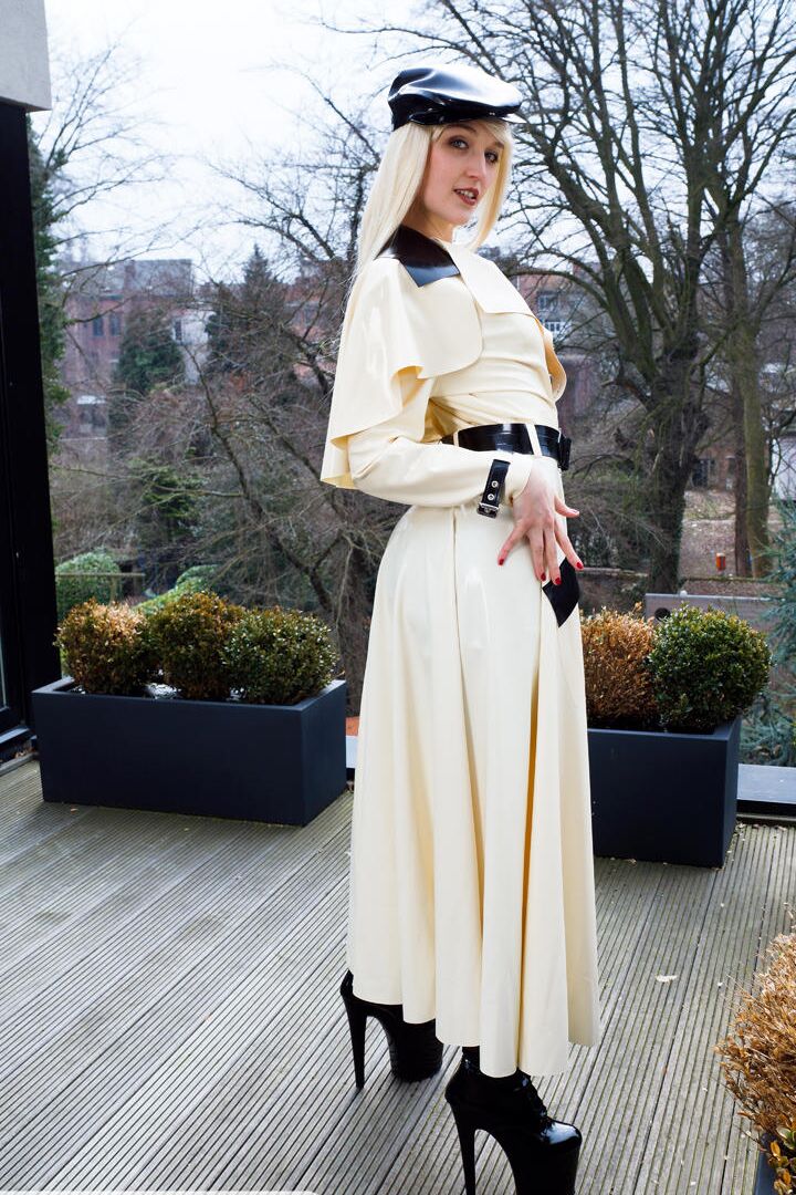 16P Classy blonde flashes the village below on her patio in latex attire