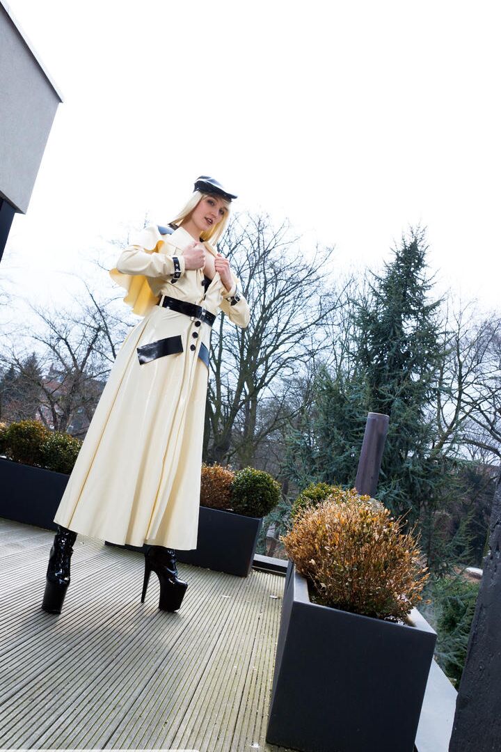 16P Classy blonde flashes the village below on her patio in latex attire