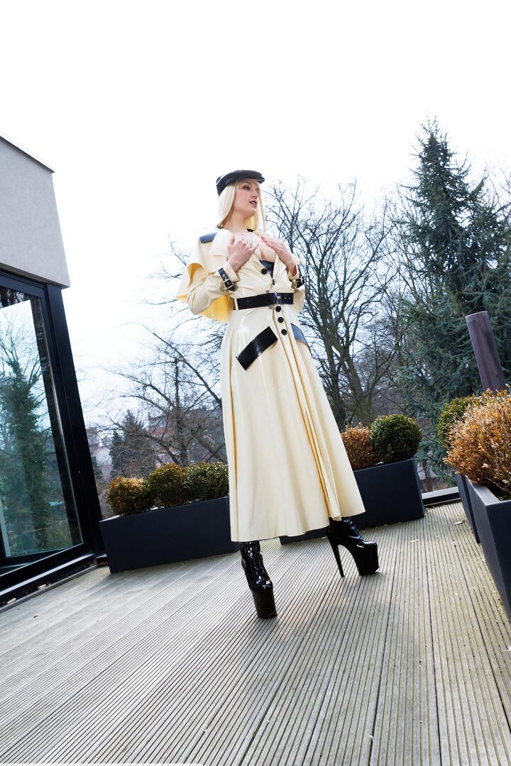 16P Classy blonde flashes the village below on her patio in latex attire