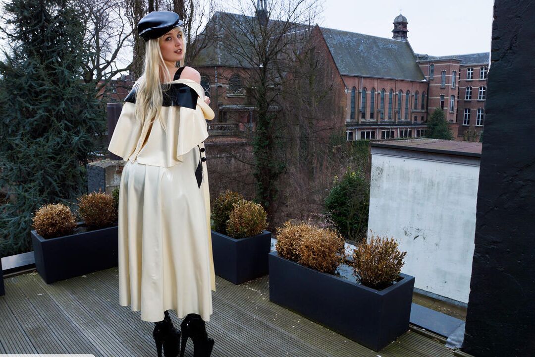 16P Classy blonde flashes the village below on her patio in latex attire