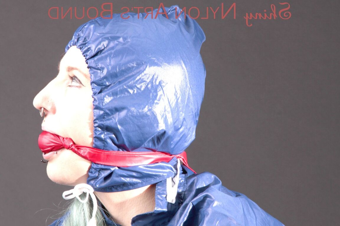 16P Mara wearing a rain skirt and a rain coat with rubber boots being tied and