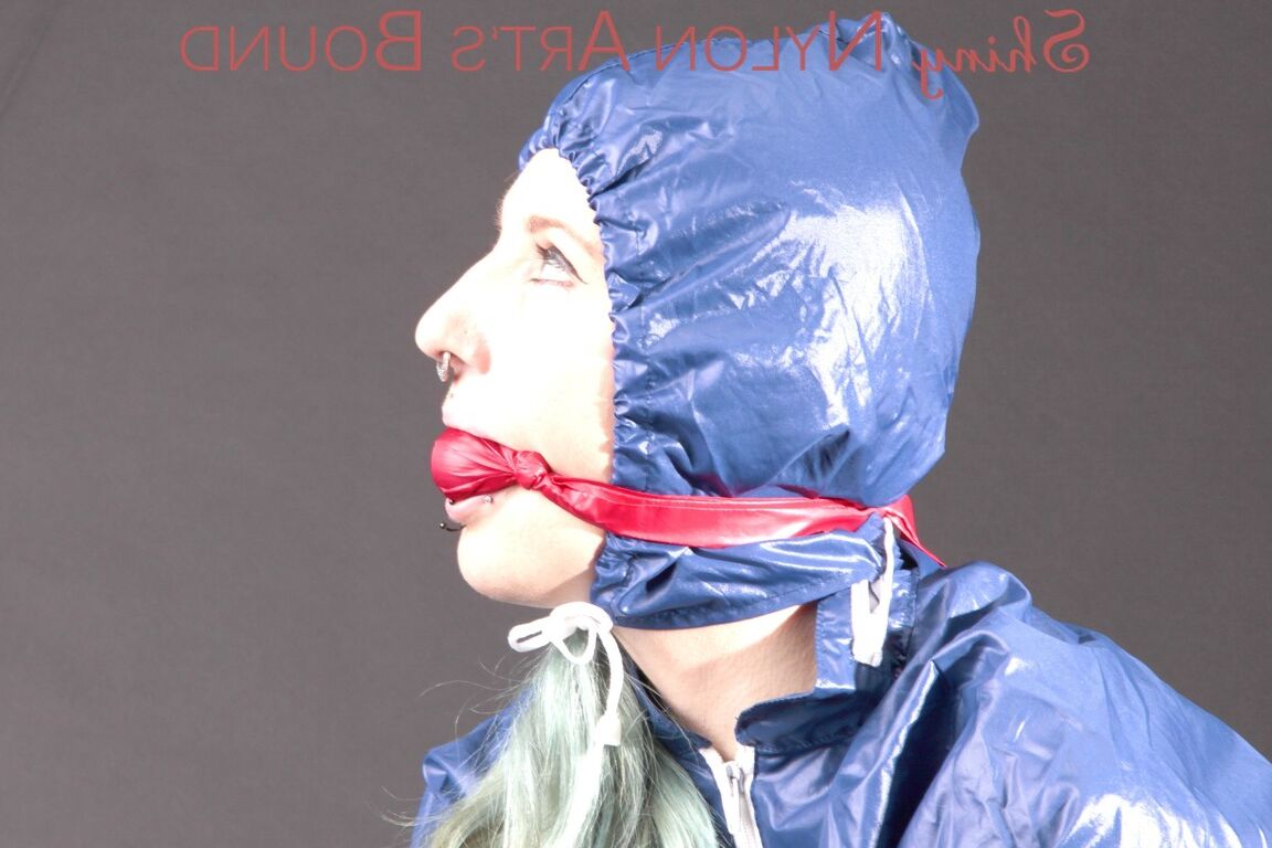 16P Mara wearing a rain skirt and a rain coat with rubber boots being tied and