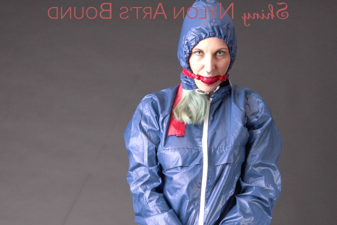 16P Mara wearing a rain skirt and a rain coat with rubber boots being tied and