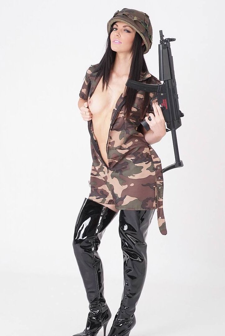 15P Sexy brunette releases her tits from a camouflage dress while wielding a rifle
