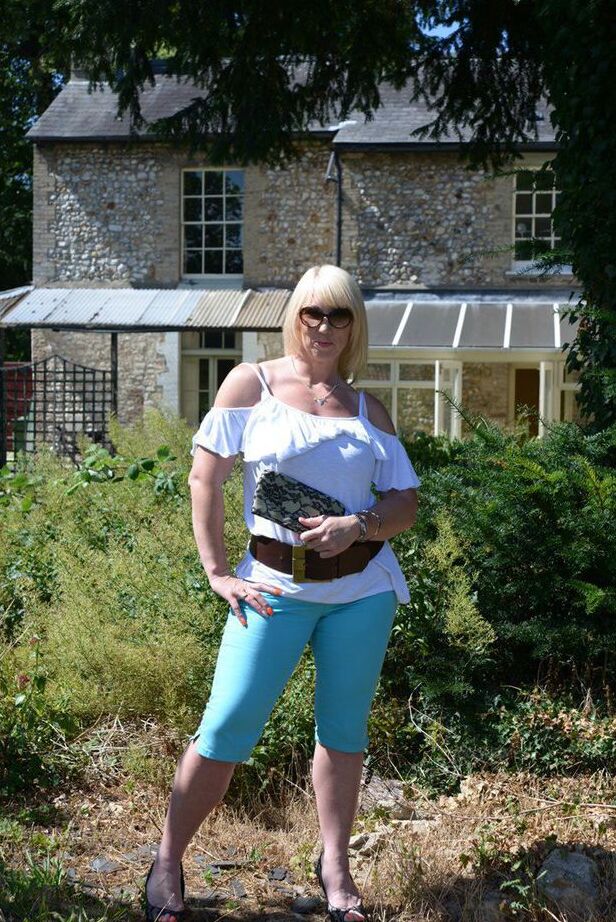 20P Middle-aged blonde Melody models in a bra while in a backyard