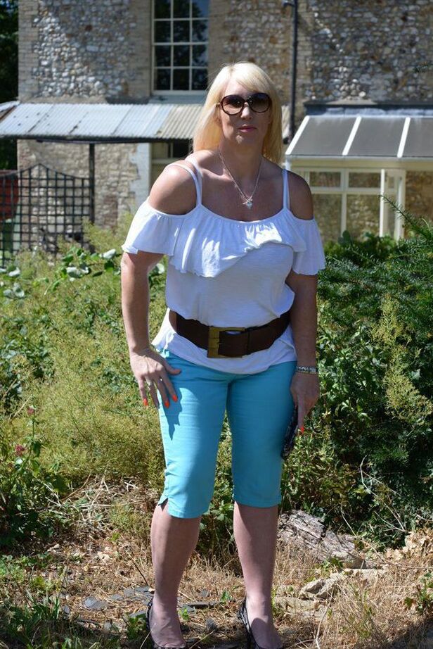 20P Middle-aged blonde Melody models in a bra while in a backyard