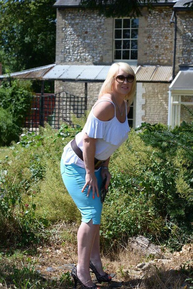 20P Middle-aged blonde Melody models in a bra while in a backyard