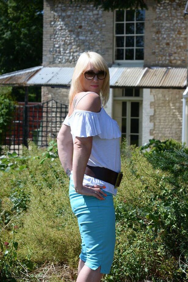 20P Middle-aged blonde Melody models in a bra while in a backyard