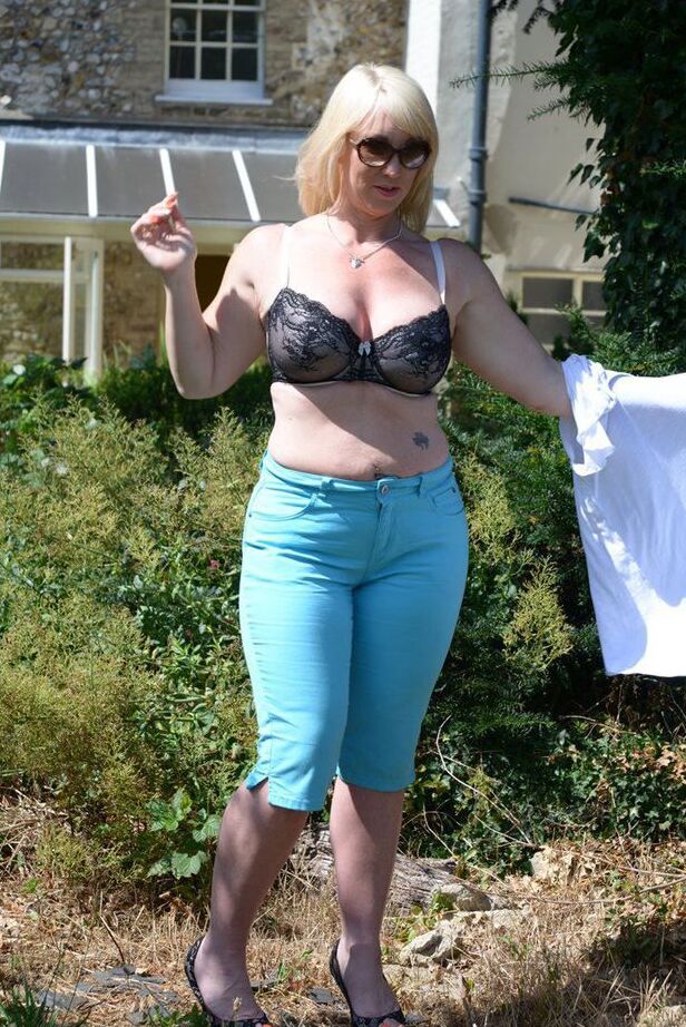 20P Middle-aged blonde Melody models in a bra while in a backyard