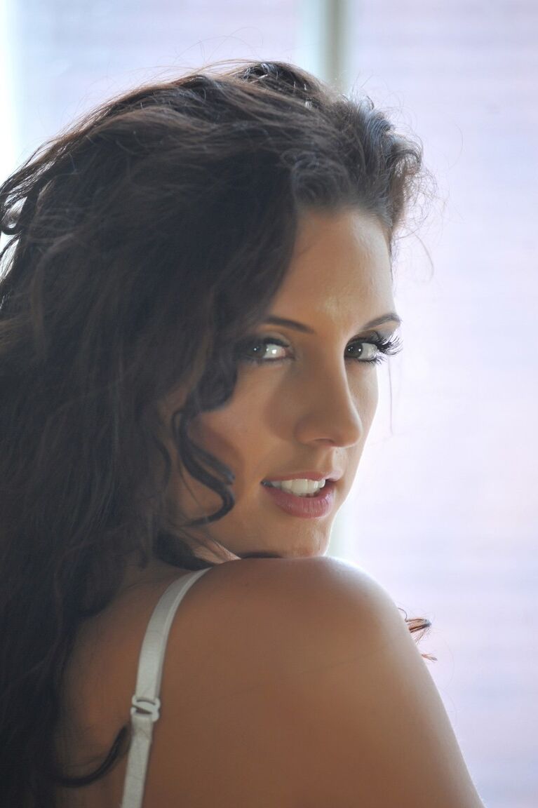 12P Hot brunette Nicola models white bra and panty ensemble in solo action