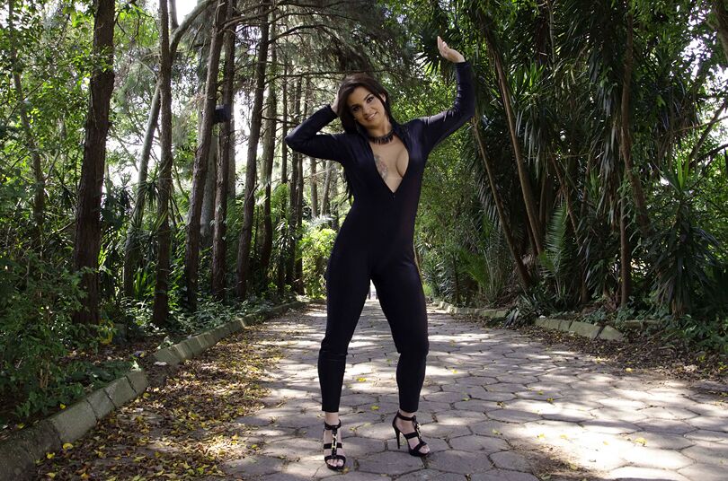 16P A beleza latina de fundo grande Cristine Castellari posando totalmente vestida do lado de fora