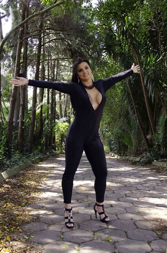16P A beleza latina de fundo grande Cristine Castellari posando totalmente vestida do lado de fora
