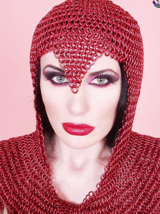 15P Busty chick Morrigan Hel licks a dagger while wearing chain mail and OTK boots