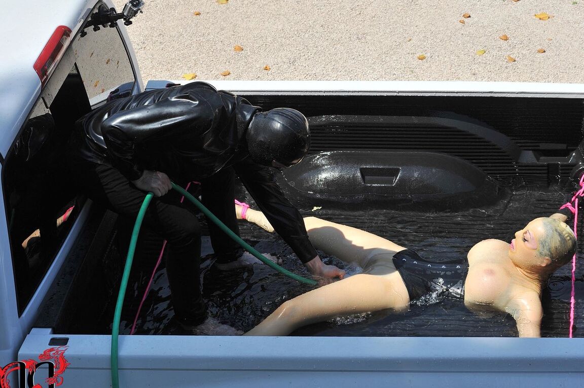 21P British girl in latex Latex Lucy gets tied on a truck & water jetted in BDSM
