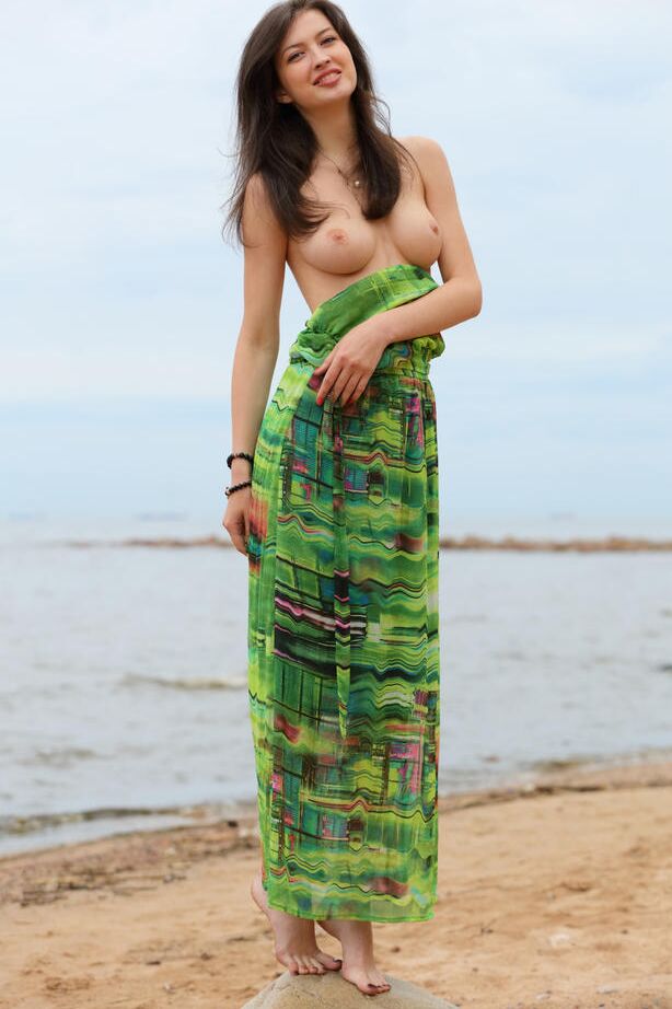 16P A adolescente esbelta Ganna A deixa cair seu vestido longo para exibir seios perfeitos na praia
