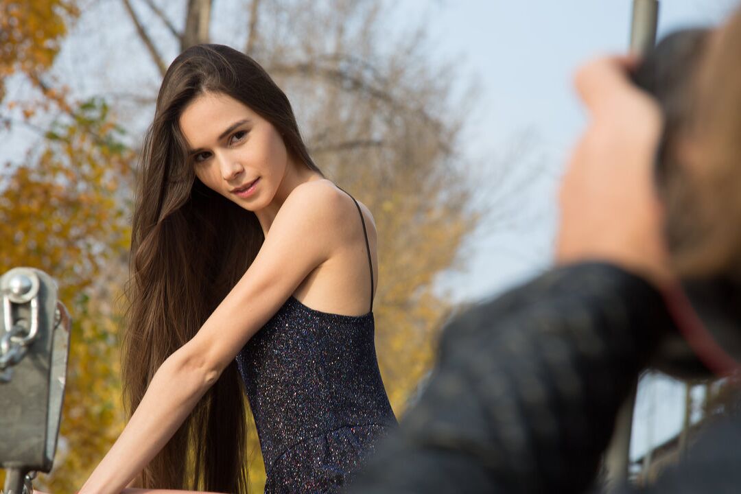 16P Long legged model Leona Mia begins to disrobe up against a retaining wall
