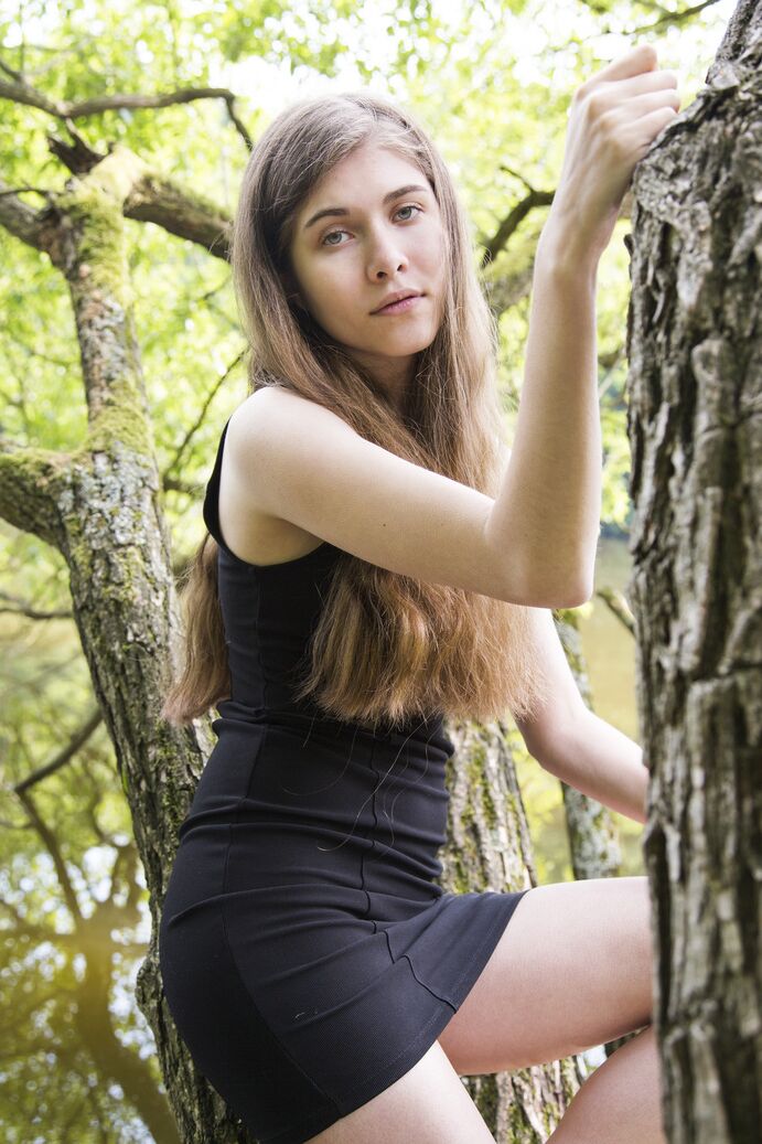 20P A adolescente descalça Londa tira um vestido preto para posar nua em uma árvore