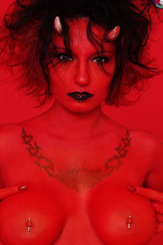 16P La chica tatuada y con piercings Nina Sin luce una mirada diabólica durante un concierto desnuda