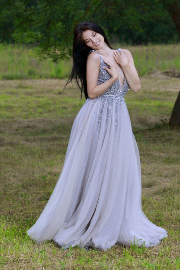 Die 18-jährige dunkelhaarige Teenagerin Aleksandrina schlüpft aus ihrem Ballkleid und posiert nackt auf einem Feld