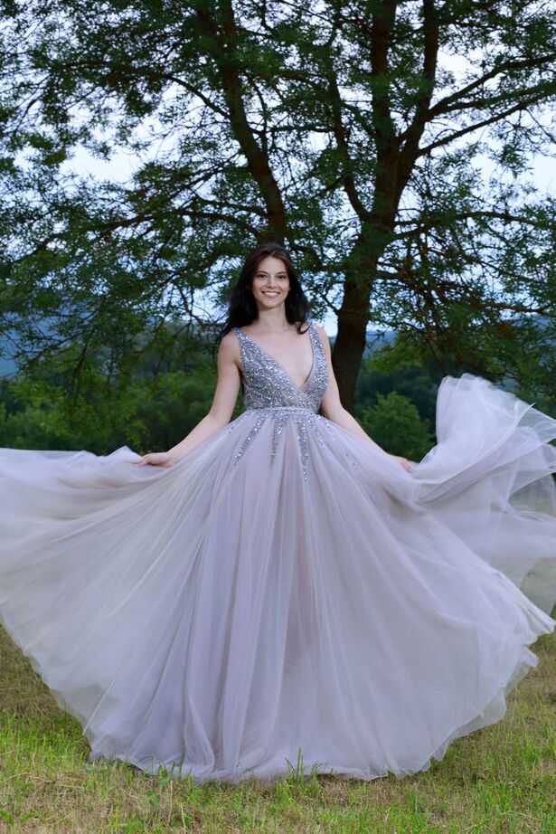 Die 18-jährige dunkelhaarige Teenagerin Aleksandrina schlüpft aus ihrem Ballkleid und posiert nackt auf einem Feld