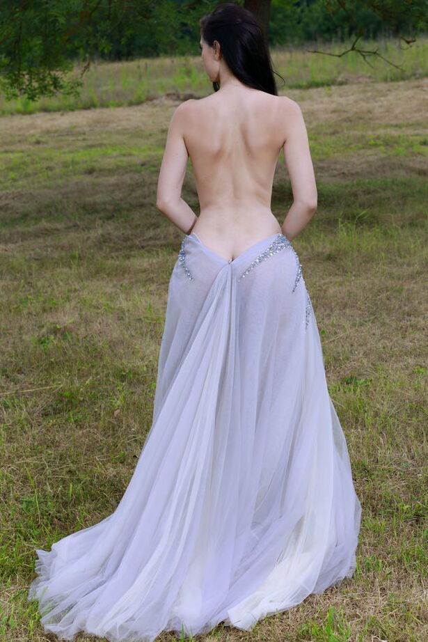 Die 18-jährige dunkelhaarige Teenagerin Aleksandrina schlüpft aus ihrem Ballkleid und posiert nackt auf einem Feld
