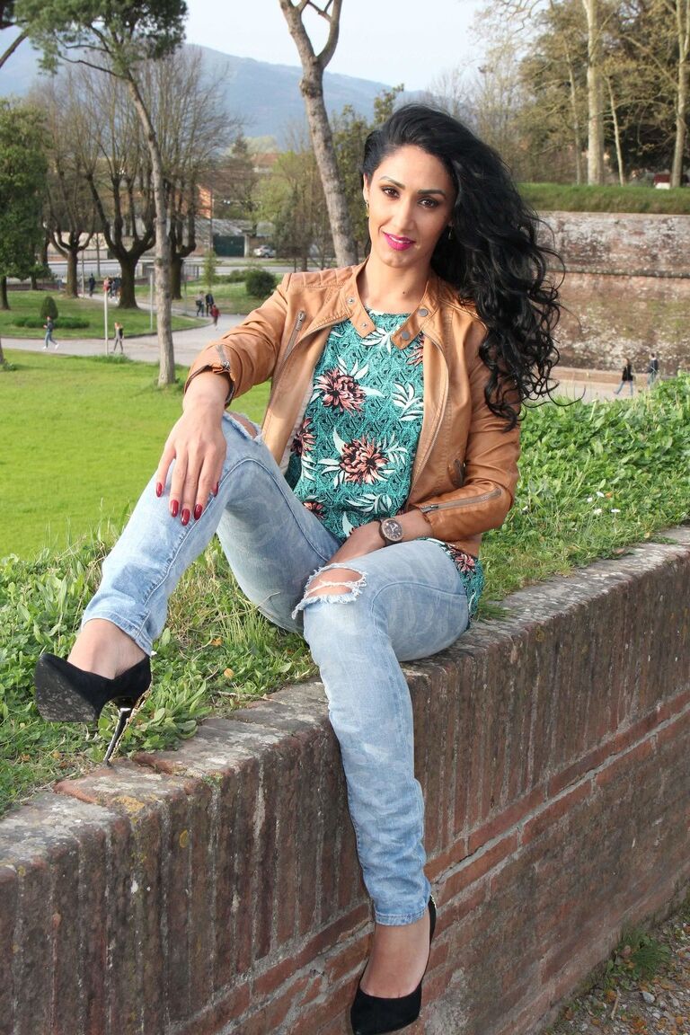 12P Dark-haired female Mistress Alexya displays her bare feet in a public setting