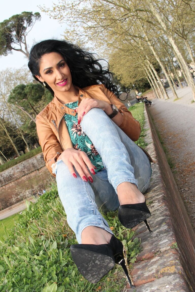 12P Dark-haired female Mistress Alexya displays her bare feet in a public setting