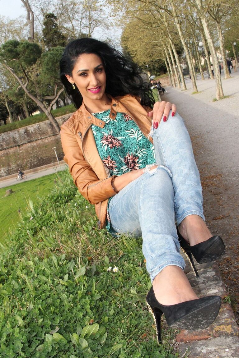 12P Dark-haired female Mistress Alexya displays her bare feet in a public setting