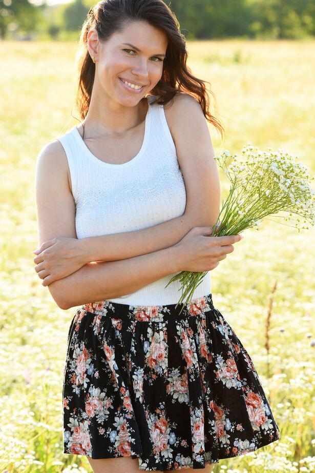 18P Die junge Brünette Suzanna A steht nackt, nachdem sie sich auf einem Feld voller Wildblumen entkleidet hat