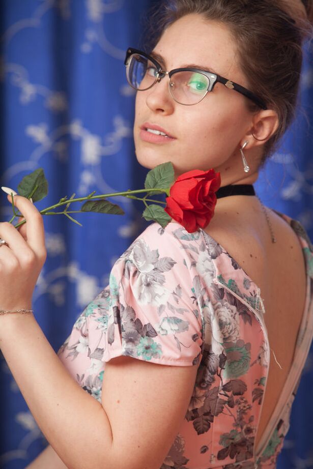 16P Nerdy 18 year old Liza Loo holds a rose showing her firm breasts in glasses