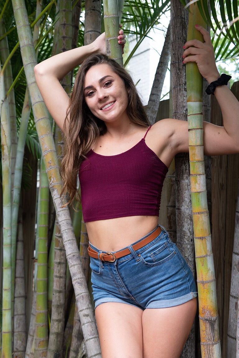 21P La jolie brune Mackenzie Mace perd lentement ses vêtements et pose en extérieur