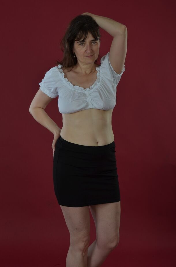 20P Amateur model uncovers saggy tits before sliding black miniskirt over bare ass