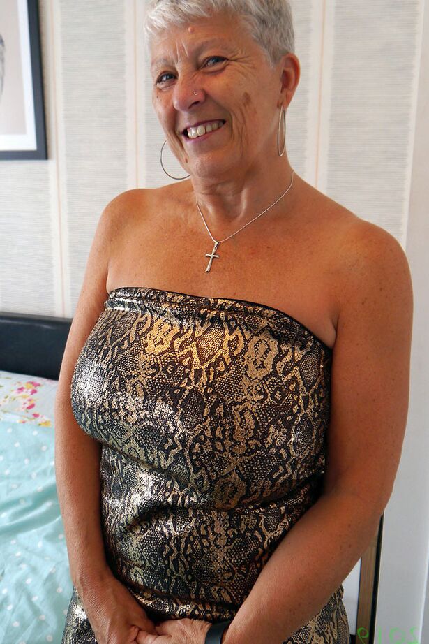 20P Short haired granny Savana unleashes her large breasts while on her bed