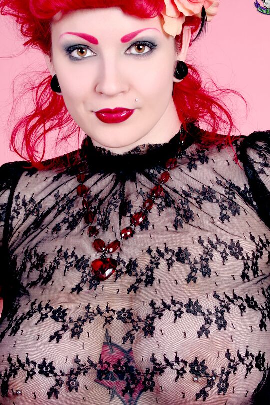 18P A modelo ruiva Xanthia Doll posa sem nudez com blusa transparente e saia de látex