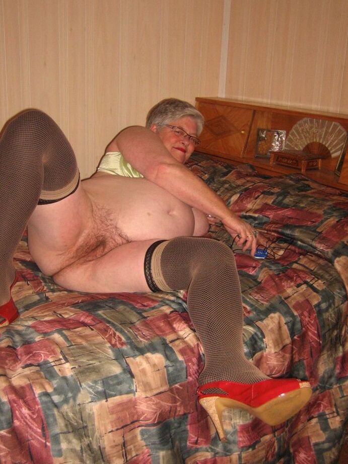 20P La grosse mamie Girdle Goddess caresse sa chatte après s'être déshabillée en bas sur son lit
