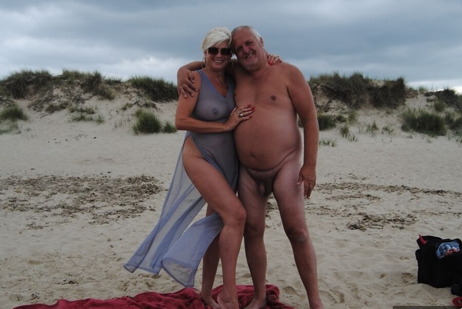20P La blonde mature Dimonty mange une friandise glacée après avoir posé nue sur une plage