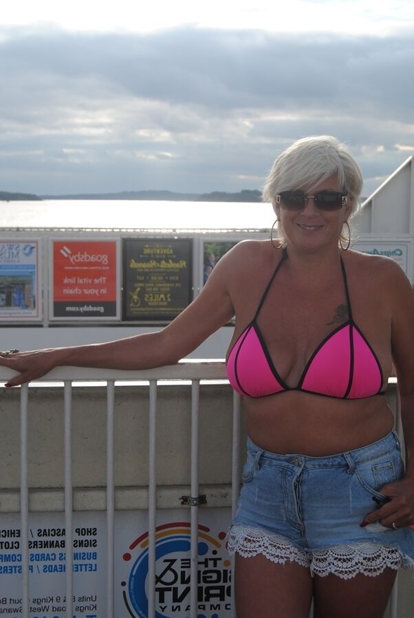 20P La blonde mature Dimonty mange une friandise glacée après avoir posé nue sur une plage