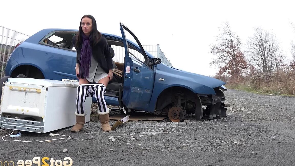 15P Eveline squats behind an abandoned car to pee