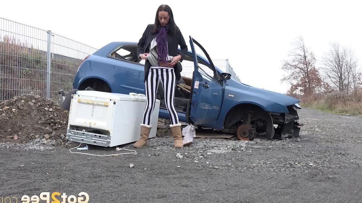15P Eveline squats behind an abandoned car to pee