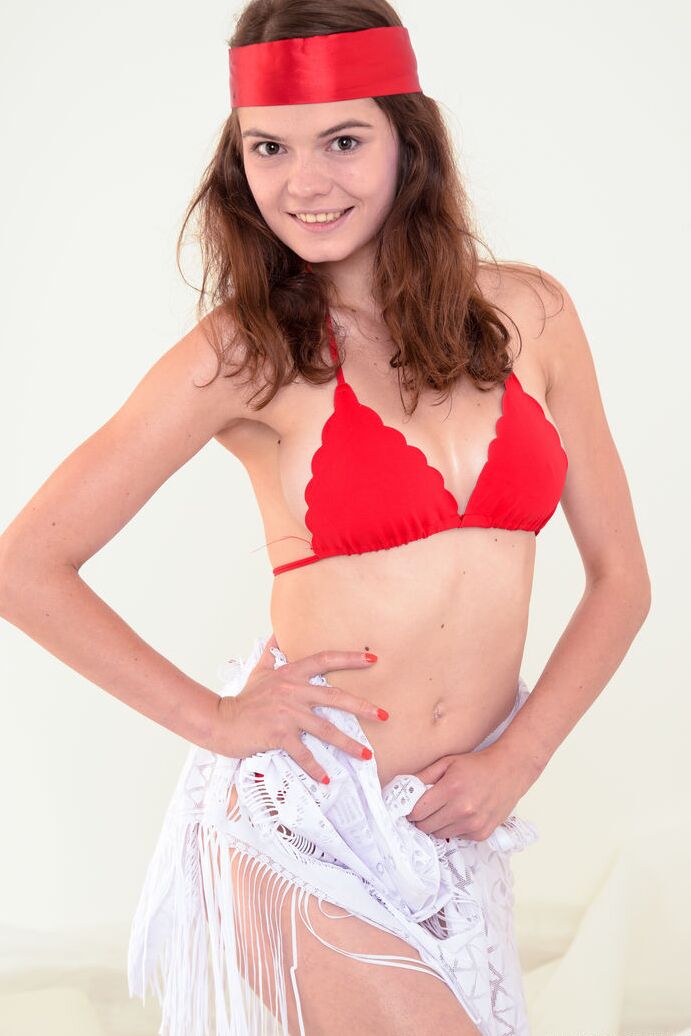 20P Slim teen Kitry works a red fan while getting completely naked