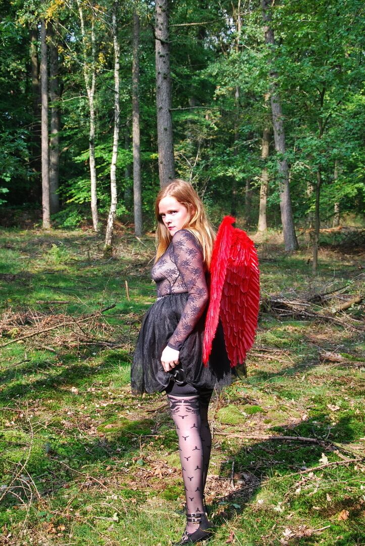 20P Une fille solo amateur arbore des ailes d'ange tout en modélisant de la lingerie sur une souche d'arbre