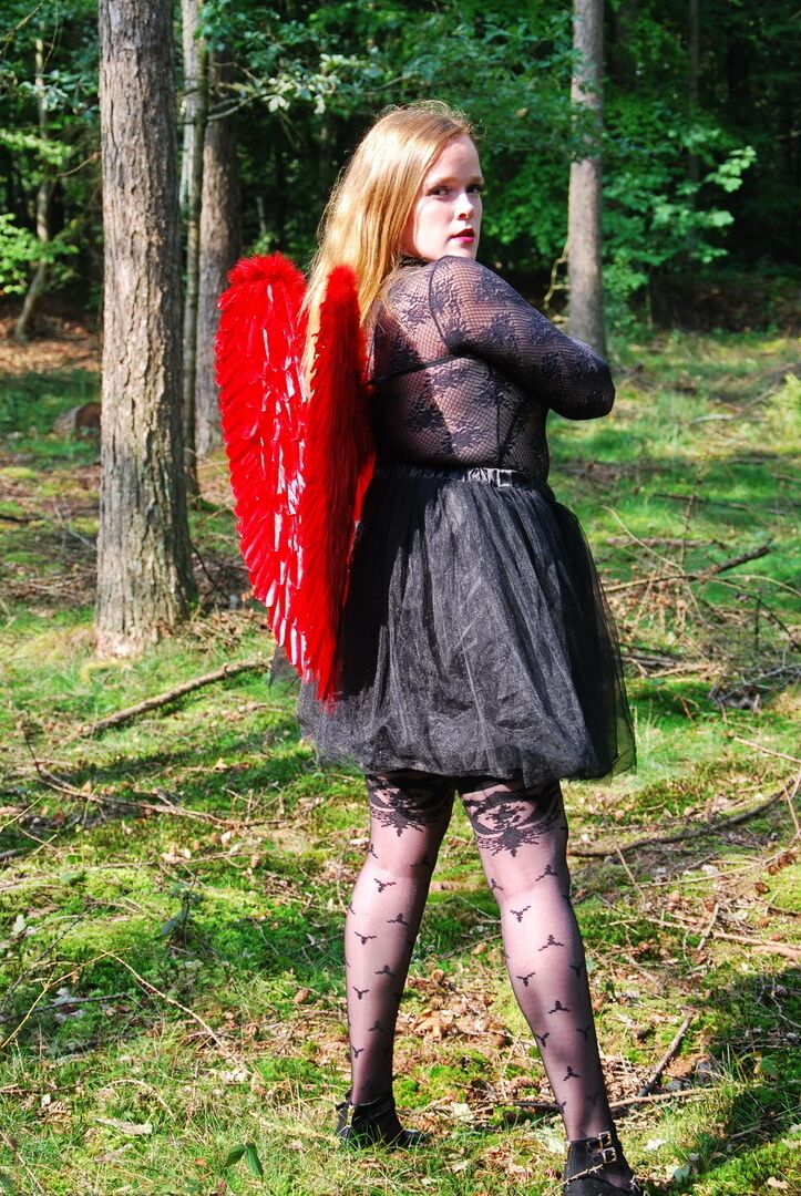 20P Une fille solo amateur arbore des ailes d'ange tout en modélisant de la lingerie sur une souche d'arbre