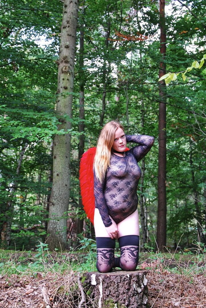20P Une fille solo amateur arbore des ailes d'ange tout en modélisant de la lingerie sur une souche d'arbre
