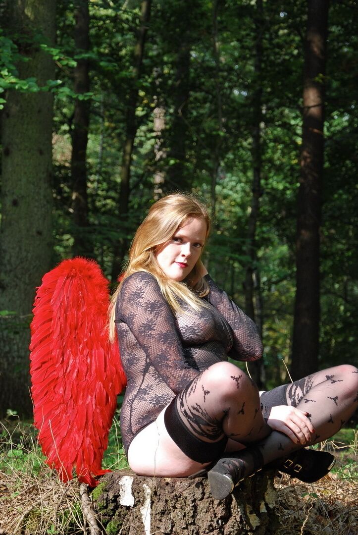 20P Une fille solo amateur arbore des ailes d'ange tout en modélisant de la lingerie sur une souche d'arbre