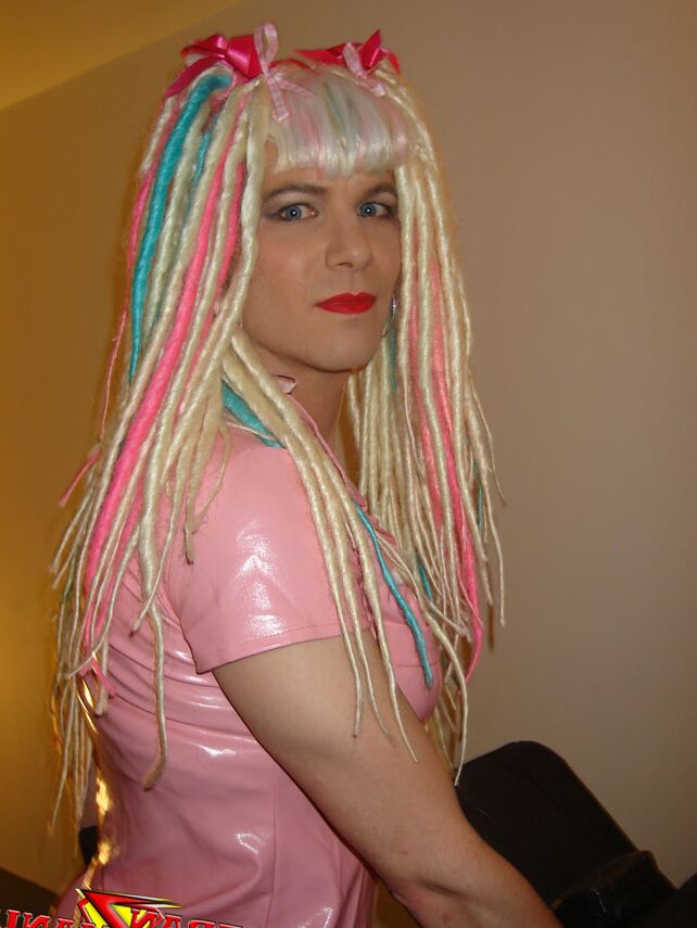 15P Naughty crazy haired crossdresser wearing pink pvc gets ready to go on the