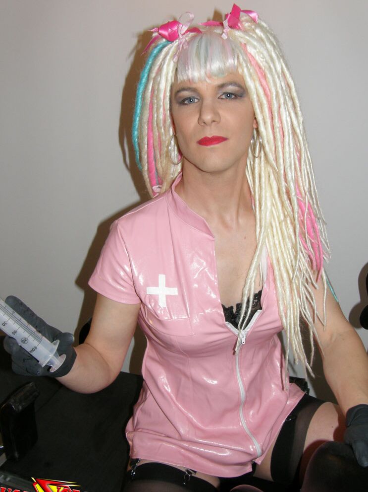 15P Naughty crazy haired crossdresser wearing pink pvc gets ready to go on the