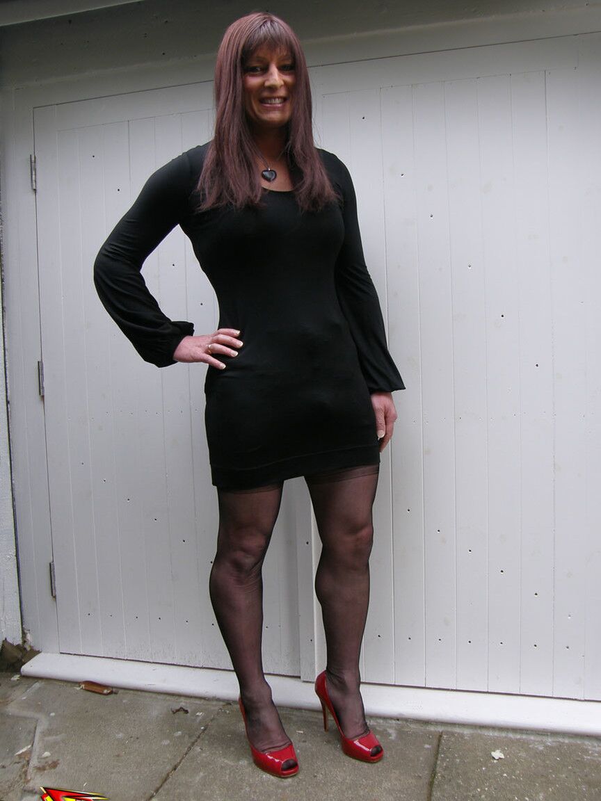 15P Crossdresser sexy de cabelos compridos com um grande sorriso provocando em nylon sedoso