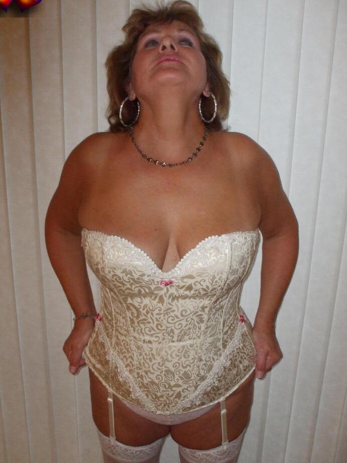 20P Busty Bliss mais velha e excitada em lingerie de cetim branco se curva para exibir sua bunda grande