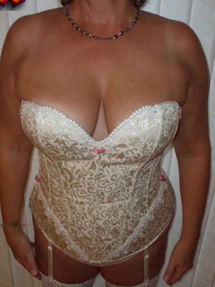 20P Busty Bliss mais velha e excitada em lingerie de cetim branco se curva para exibir sua bunda grande