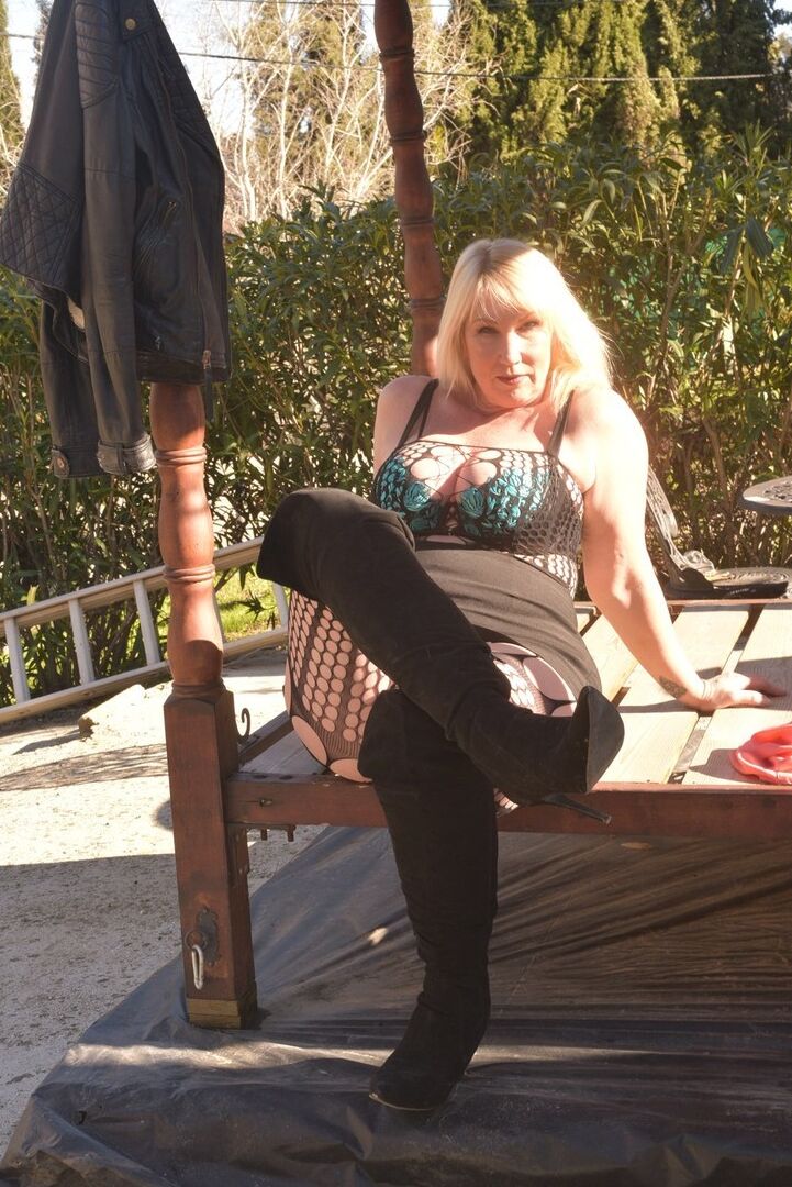 Die 16P übergewichtige Blondine Melody entblößt ihren Büstenhalter auf einer Terrasse in OTK-Stiefeln